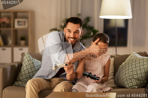 Image of father and daughter playing video game at home