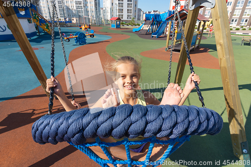 Image of Girls ride a big round hanging swing