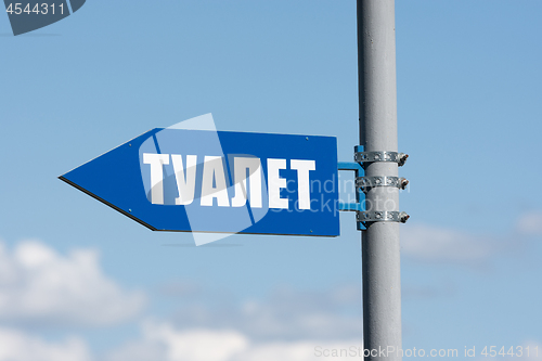 Image of Signpost on the street in the form of an arrow and the words \"toilet\"