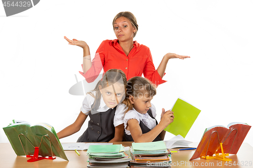 Image of Two girls are pushing while sitting at a desk, the teacher does not know what to do with it