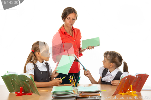 Image of Upset children hand over notebooks to teacher