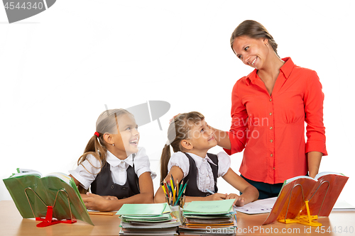 Image of Kind teacher communicates with students sitting at a desk