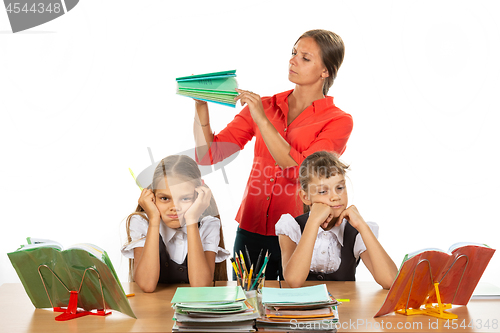 Image of The teacher considers the number of notebooks handed over, the girls in the foreground frankly miss