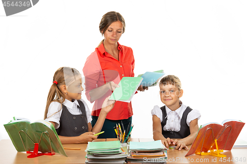 Image of Pupils hand over notebooks with homework to teacher