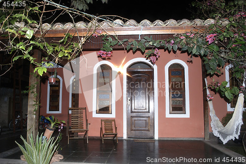 Image of Porch of a colonial red house at night