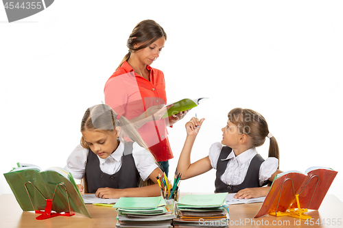 Image of The teacher helps the schoolgirl to understand the task