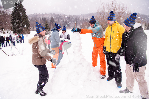 Image of group of young people making a snowman