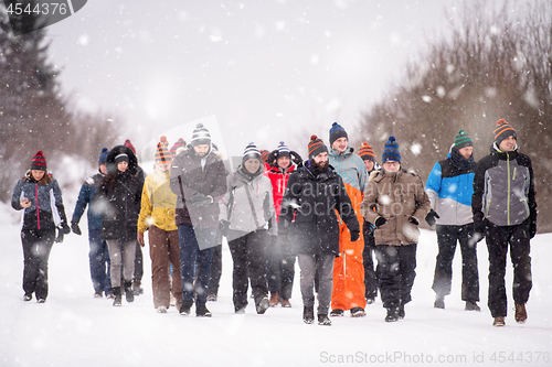 Image of group of young people walking through beautiful winter landscape