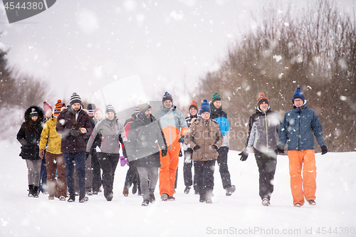 Image of group of young people walking through beautiful winter landscape