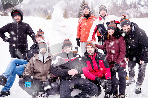 Image of group portait of young people posing with snowman