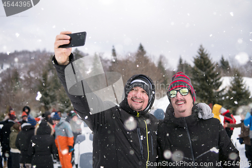 Image of group of young people taking selfie in beautiful winter landscap