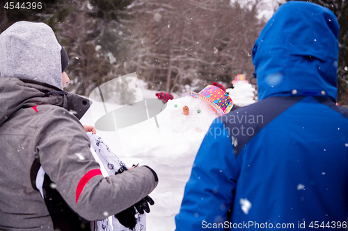 Image of group of young people making a snowman