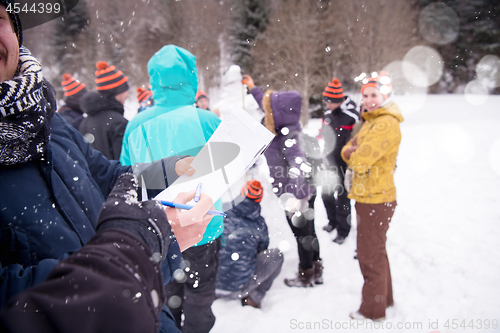 Image of young people measuring the height of finished snowman