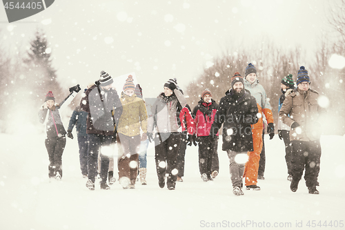 Image of group of young people walking through beautiful winter landscape