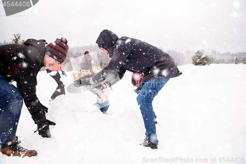 Image of group of young people making a snowman