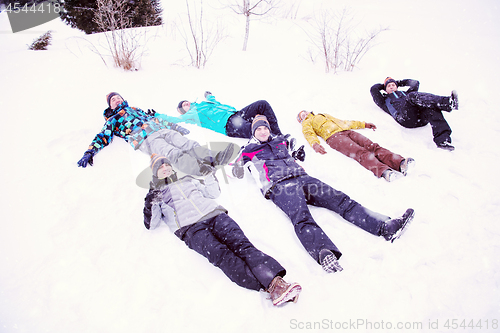 Image of group of young people laying on snow and making snow angel