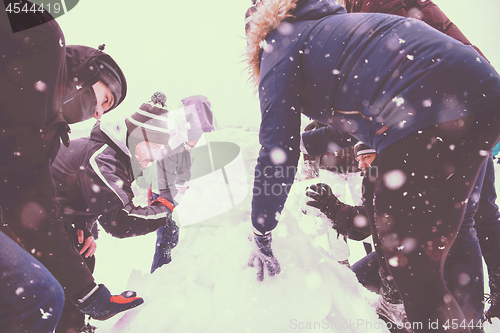 Image of group of young people making a snowman