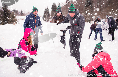 Image of group of young people making a snowman