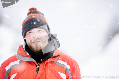 Image of Portrait of young man on snowy winter day