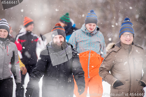 Image of group of young people walking through beautiful winter landscape