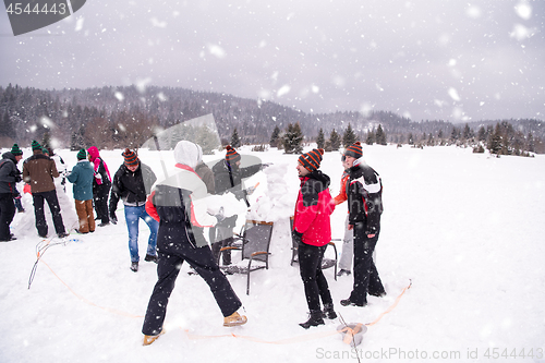 Image of group of young people making a snowman