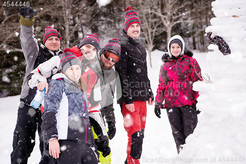 Image of group portait of young people posing with snowman