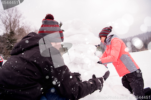 Image of group of young people making a snowman