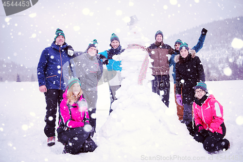 Image of group portait of young people posing with snowman