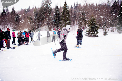 Image of group of young people having a running competition on winter day