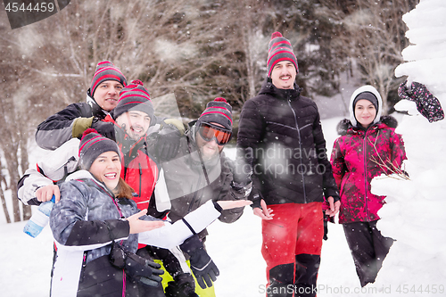 Image of group portait of young people posing with snowman