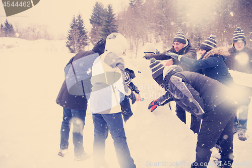 Image of group of young people making a snowman