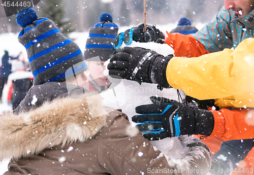 Image of group of young people making a snowman