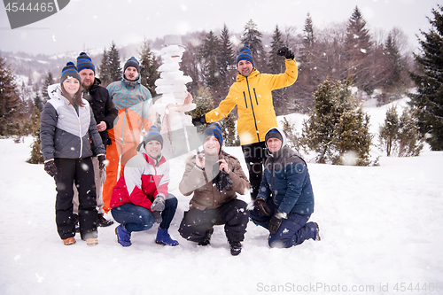 Image of group portait of young people posing with snowman