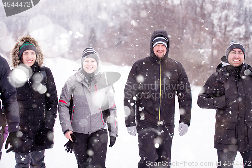 Image of group of young people walking through beautiful winter landscape