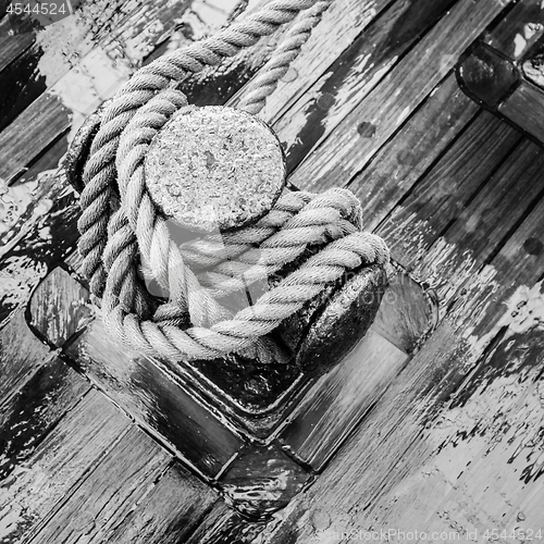 Image of Bollard with a rope on the wooden deck of a sailing vessel, clos
