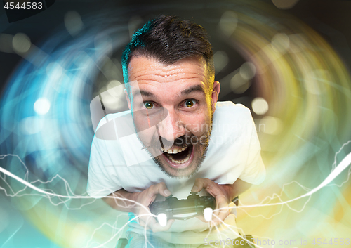 Image of Enthusiastic gamer. Joyful young man holding a video game controller