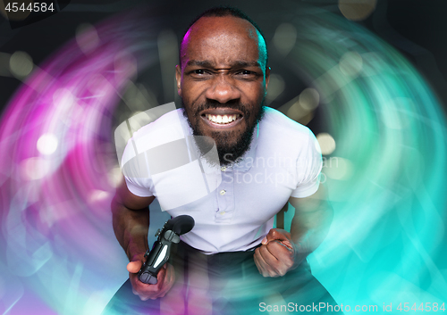 Image of Enthusiastic gamer. Joyful young man holding a video game controller