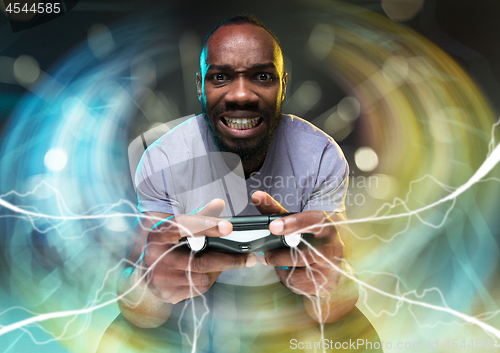 Image of Enthusiastic gamer. Joyful young man holding a video game controller