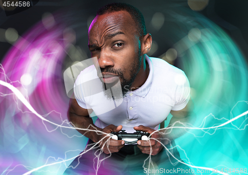 Image of Enthusiastic gamer. Joyful young man holding a video game controller