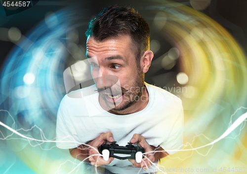 Image of Enthusiastic gamer. Joyful young man holding a video game controller