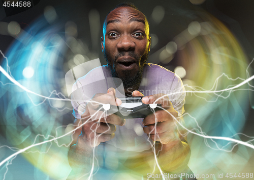 Image of Enthusiastic gamer. Joyful young man holding a video game controller