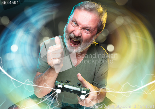 Image of Enthusiastic gamer. Joyful man holding a video game controller