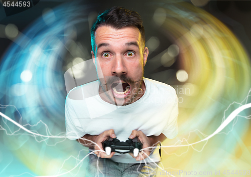 Image of Enthusiastic gamer. Joyful young man holding a video game controller