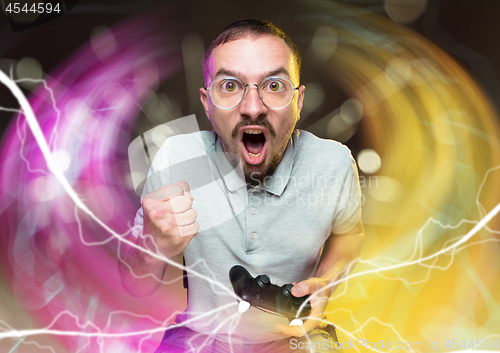 Image of Enthusiastic gamer. Joyful young man holding a video game controller