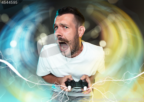 Image of Enthusiastic gamer. Joyful young man holding a video game controller