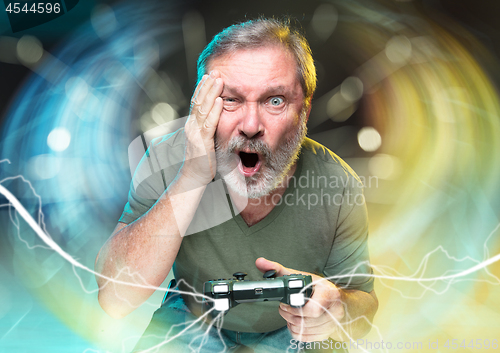 Image of Enthusiastic gamer. Joyful man holding a video game controller