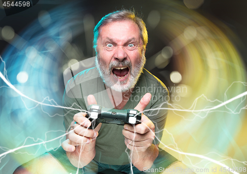 Image of Enthusiastic gamer. Joyful man holding a video game controller