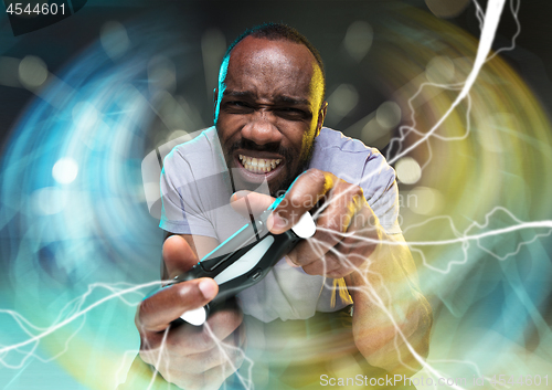 Image of Enthusiastic gamer. Joyful young man holding a video game controller