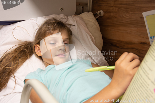 Image of Girl solves a crossword puzzle on the top shelf of a reserved seat car