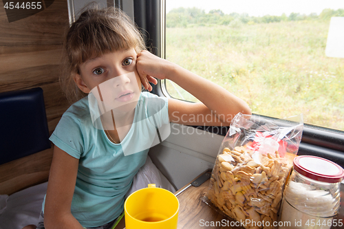 Image of Girl sitting in a reserved seat carriage in a train funny looks in the frame